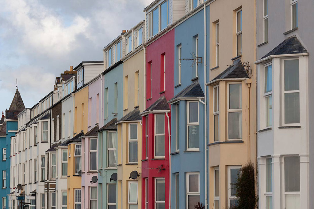 Multi-coloured terraced houses, cloudy sky above