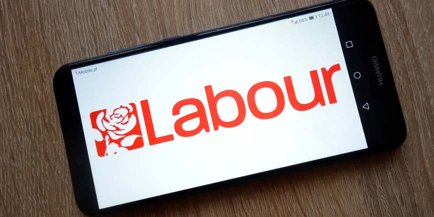 Labour party logo displayed on a tablet, inclined at a slight angle on a table